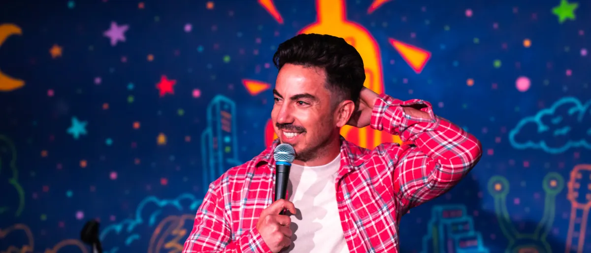 Evan Lopez performing stand-up comedy on stage in Austin